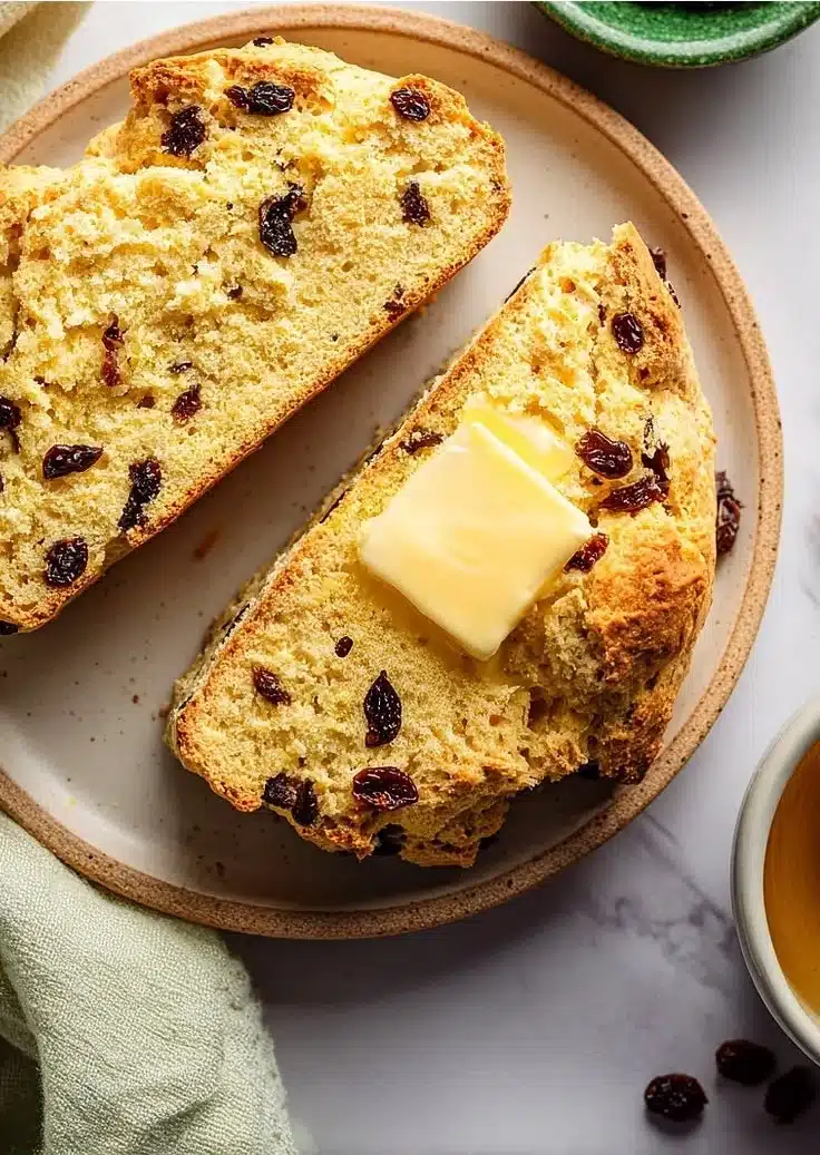 Freshly baked Irish soda bread with currants on a wooden table.