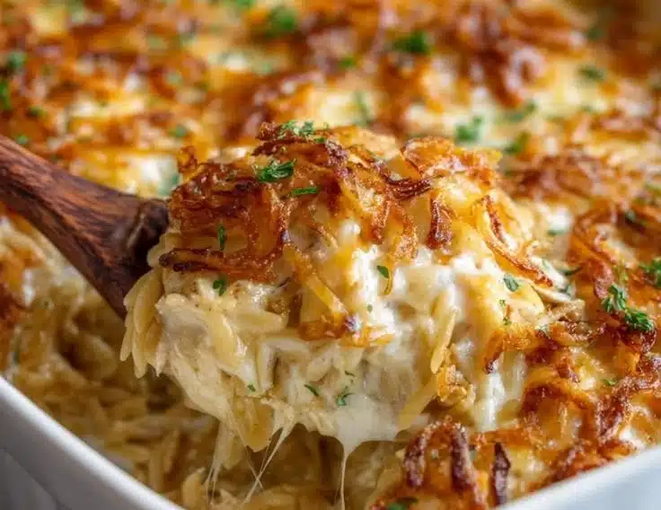 Baked French Onion Chicken Orzo Casserole topped with melted cheese and herbs