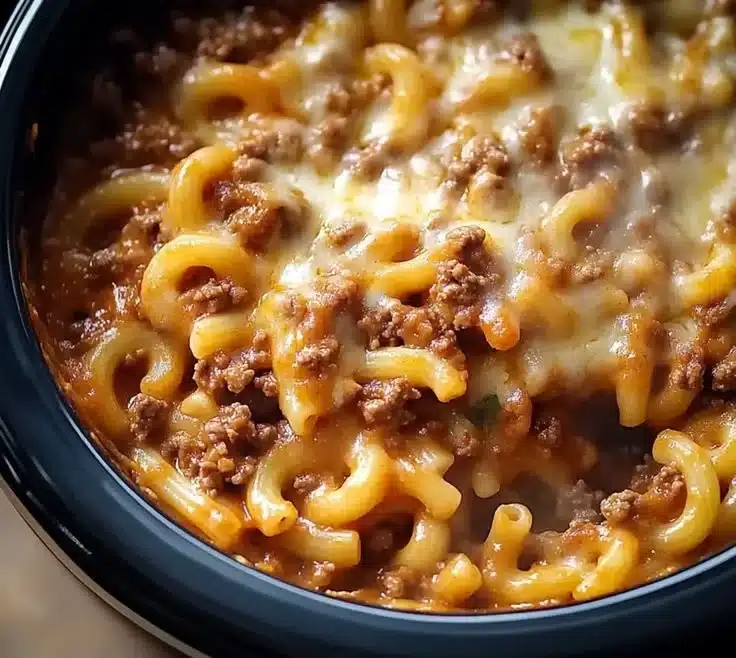 Delicious homemade crockpot ground beef pasta served in a bowl with herbs.