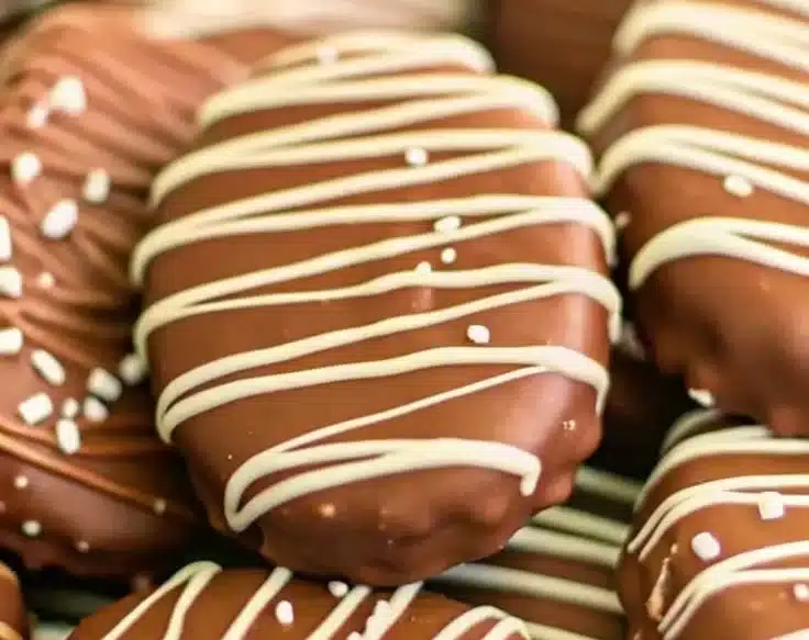 Homemade peanut butter eggs on a plate, covered in chocolate.