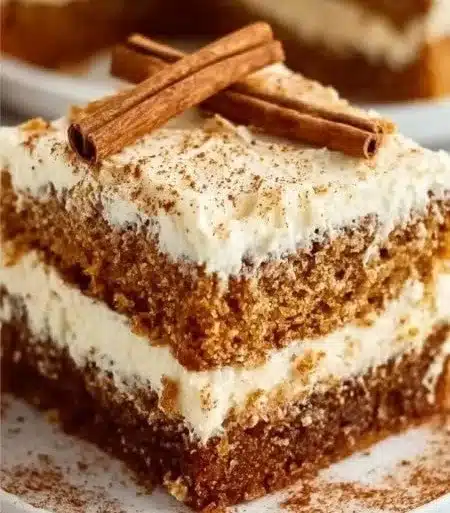 A slice of healthy carrot cake topped with cream cheese frosting and walnuts.